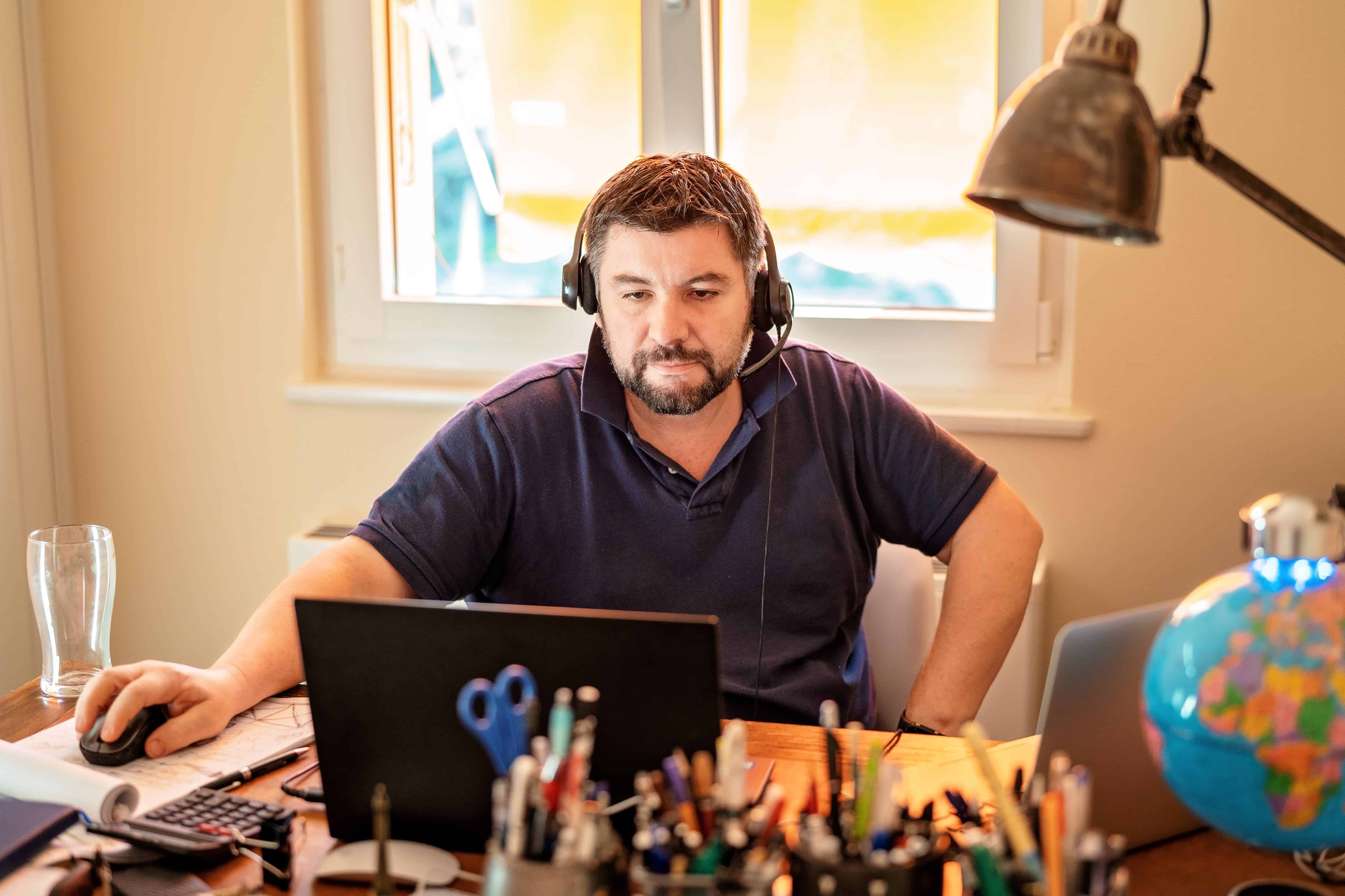 man-with-headphones-and-microphone-having-conference-call-online